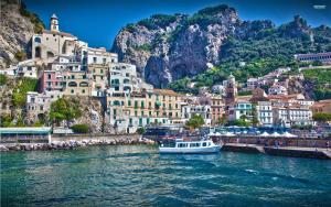 un barco en el agua frente a una ciudad en Dolce Vita A, en Amalfi