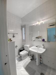 a white bathroom with a sink and a toilet at Apartamento Santa Cruz Casco Antiguo con Terraza in Seville