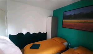 1 dormitorio con cama y pared verde en Room Nicole, not for parties, not a hotel en Ámsterdam