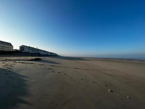a view of a beach with footprints in the sand at Duplex moderne à 700m de la plage Parking & WiFi in Fort-Mahon-Plage +15 photos