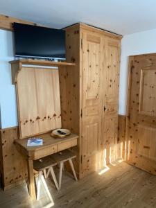 サメーダンにあるRelaxing confortable studio, heated garage, skiroomの木製テーブルと木製キャビネット付きの客室です。