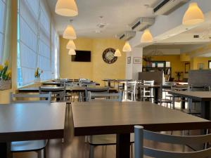 a restaurant with tables and chairs and a clock on the wall at Hotel Alverì in Mestre