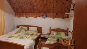 a bedroom with two beds and a clock on the wall at Guesthouse Mijatovic in Žabljak