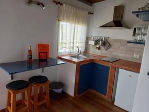cocina con encimera, fregadero y taburetes en Orange House, en Vallehermoso