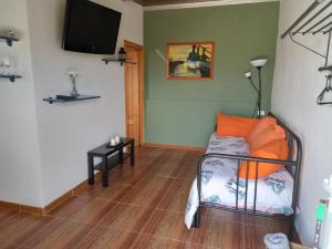 Habitación con cama y TV en la pared. en Orange House, en Vallehermoso