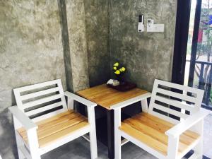 2 chaises blanches, une table, une table et des chaises dans l'établissement Lanta smile inn, à Ko Lanta