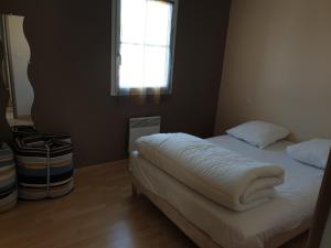 a small bedroom with a bed with a window at Maison des Trèmières in Brem-Sur-Mer