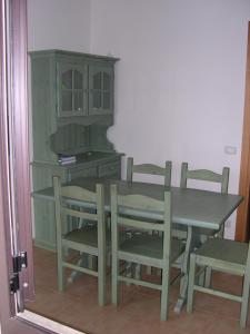 a table and chairs and a cabinet in a room at Baia dei Canonici in Catanzaro Lido