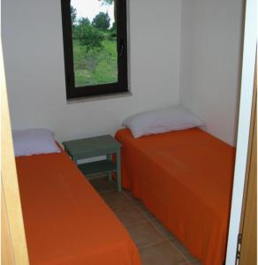 two beds in a room with a window at Baia dei Canonici in Catanzaro Lido