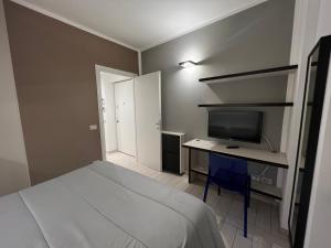 sypialnia z łóżkiem i biurkiem z telewizorem w obiekcie Al Piano 1 w mieście Ancona