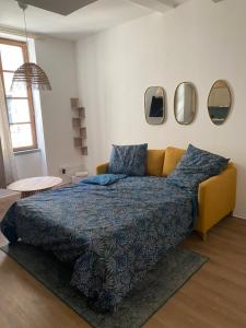 una camera da letto con un letto e specchi sul muro di Le Bout du Monde Appartement Hyper-centre a Carcassonne