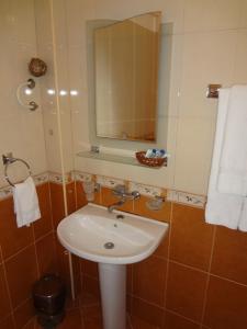 W łazience znajduje się biała umywalka i lustro. w obiekcie Vidin Hotel w mieście Widyń
