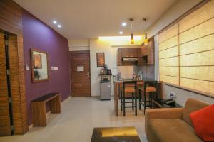 a living room and kitchen with a couch and a table at The Gold Haven in Pune