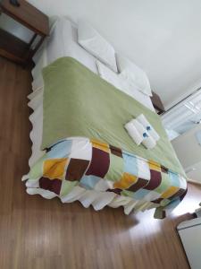 a bed with a colorful blanket and pillows on it at Pousada Vale do Garimpeiro in Diamantina