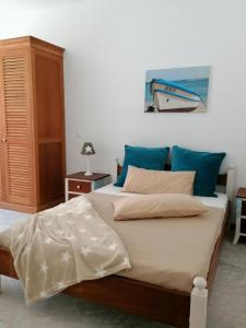 a bedroom with a large bed with blue pillows at Villa Pescadora spectacular view, luxery fisherhouse design in Sal Rei