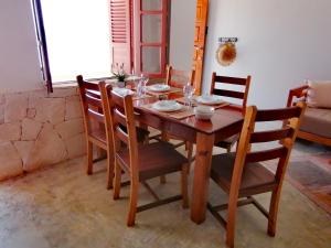 a wooden dining room table with chairs and glasses on it at Villa Pescadora spectacular view, luxery fisherhouse design in Sal Rei +20 photos