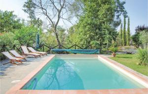 una piscina con 2 tumbonas junto a un patio en La Torretta, en Cortona