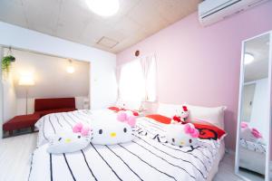 Duas camas com almofadas Hello Kitty num quarto em Higashiomi Large House em Higashiomi