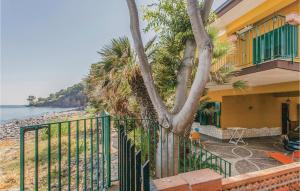 una casa con un albero vicino alla spiaggia di Praiola a San Leonardello