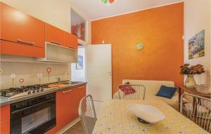 a kitchen with orange cabinets and a table and chairs at Praiola in San Leonardello