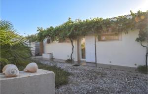 Biały budynek z winoroślą na boku w obiekcie Beautiful Home In Siracusa With Wifi w Syrakuzach