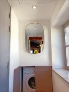 a laundry room with a washing machine and a mirror at L’UNDERGROUND Studio Hyper-Centre in Carcassonne