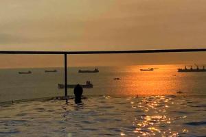 Mermaid Seaside Hotel في فنغ تاو: شخص جالس في مسبح مطل على المحيط