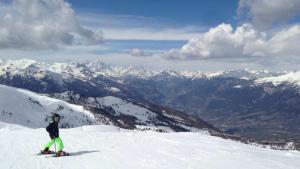 une personne debout au sommet d'une montagne enneigée dans l'établissement Appart 4 p pied des pistes Risoul 1850, à Risoul