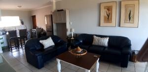 a living room with two couches and a table at Zeezicht Oceanfront with a beautiful seaview in Franskraal