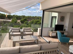 un salon avec un canapé, des fauteuils et une télévision dans l'établissement Las Colinas Golf - Naranjo 60 Penthouse, à Orihuela Costa