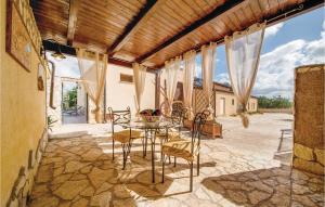 un patio con mesa y sillas en un suelo de piedra en La Mimosa en Balestrate