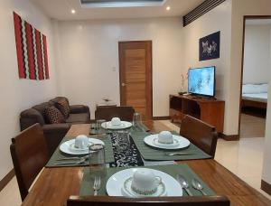 a living room with a table and chairs and a television at Le Chateau Residences in Bacolod