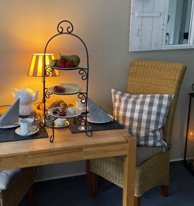 einem Tisch mit einem Teller mit Lebensmitteln und einer Lampe in der Unterkunft Hotel KAUP in Paderborn