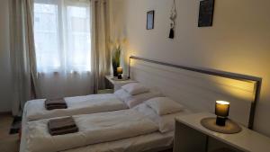 a hotel room with two beds and a window at Luna Apartman in Eger +11 photos