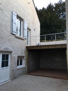 a building with a garage and a balcony at Gîte Le Relais in Mer