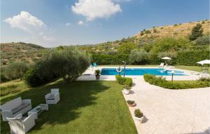 Giarratana的住宿－Villa Calaforno，享有带椅子和草坪的游泳池的顶部景致