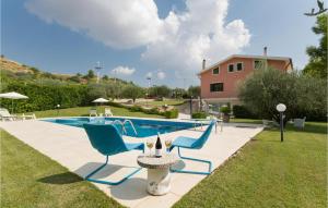 a swimming pool with two blue chairs and a table at Villa Calaforno in Giarratana