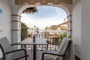 a balcony with a table and chairs and a view of the ocean at Casa de la playa Alto de el Realengo in La Herradura
