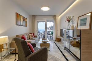 a living room with a couch and a tv at Casa de la playa Alto de el Realengo in La Herradura