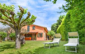 due sedie e un albero di fronte a una casa di Cozy Apartment In Cavriana With Outdoor Swimming Pool a Cavriana