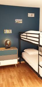 2 Etagenbetten in einem Zimmer mit blauer Wand in der Unterkunft petite maison en pierre au coeur du Périgord noir in Salignac Eyvigues