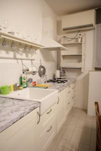 a white kitchen with a sink and a stove at Navona Dream Home in Rome