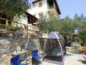 a garden with a gazebo and chairs and a building at Odyssia near the Seaside in Aghios Petros Alonissos