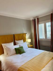 ein Schlafzimmer mit einem großen Bett mit zwei grünen Kissen in der Unterkunft Appartement Front de Mer in Canet-en-Roussillon