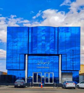 ein blaues Gebäude mit davor geparkt in der Unterkunft تــرامونتــان in Ha'il