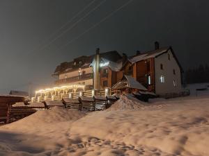 um grande edifício na neve à noite em Гук ресторанно-готельний комплекс em Bukovel