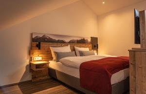 Schlafzimmer mit einem großen Bett mit einem Kopfteil aus Holz in der Unterkunft Pension Sewald in Berg