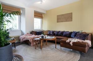 a living room with a couch and a table at Mint Mill: New riverside apartment in historic mill in Kendal