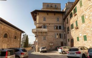 um edifício antigo com carros estacionados num parque de estacionamento em Beautiful Apartment In Assisi With 2 Bedrooms And Wifi em Assis