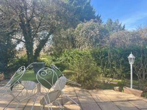 - un ensemble de chaises assises sur une terrasse dans l'établissement Un petit coin de paradis, à Bressolles